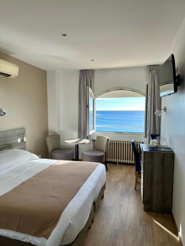une chambre d'hôtel avec un lit et une vue sur l'océan dans l'établissement Hôtel Beau Rivage, au Lavandou