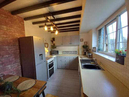 a kitchen with a white refrigerator and a table at Yewtree Cottage in Strensall