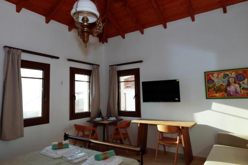 a living room with a table and a tv at Annousa's House & Studios in Kallirakhi