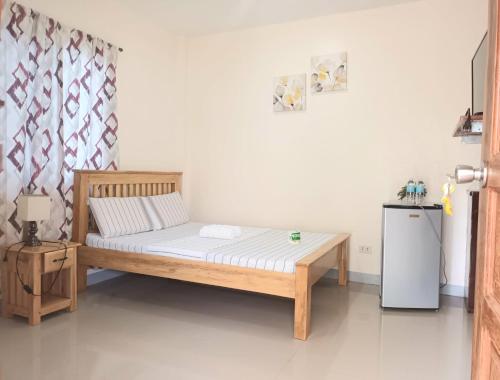 - une chambre avec un lit et un petit réfrigérateur dans l'établissement Grae’s Apartelle, à Moalboal