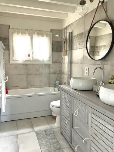 une salle de bain avec une baignoire, des toilettes et un lavabo dans l'établissement La Chambre d'hôte de Manou en Normandie, à La Noë-Poulain