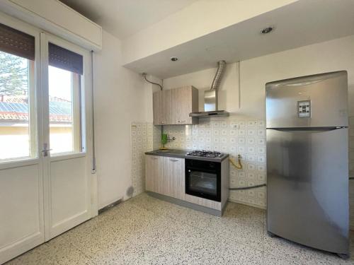 uma cozinha com um frigorífico de aço inoxidável e uma janela em Cristoforo em Bolonha