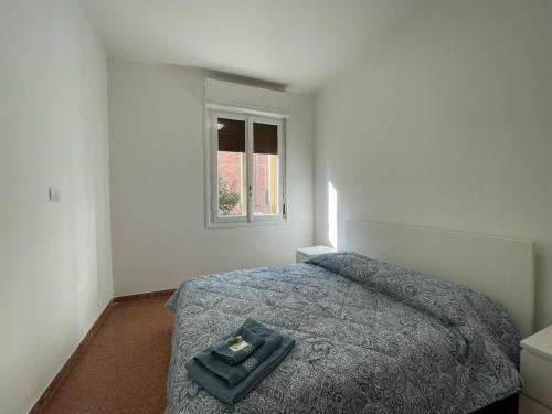 um quarto com uma cama com um cobertor azul e uma janela em Cristoforo em Bolonha