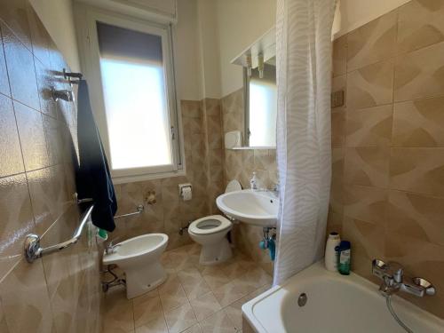 uma casa de banho com uma banheira, um lavatório e um WC. em Cristoforo em Bolonha