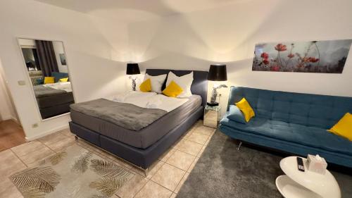 a bedroom with a bed and a blue couch at BeeFree Global Retreat7-Therme&Golf in Pocking