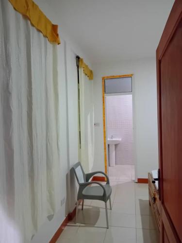 a chair sitting in a room with a bathroom at Seven Seven B&B in Arusha