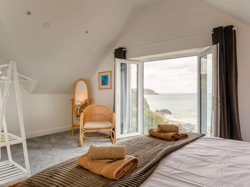 a bedroom with a bed with a view of the ocean at 2 Bed in Tresaith 89315 in Penbryn