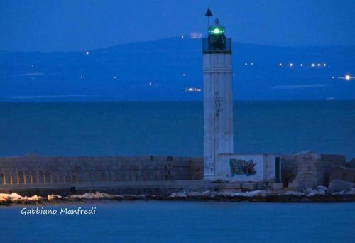 a lighthouse with a green light on top of it at Casa Tramontana in Manfredonia