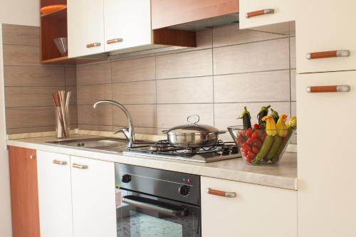 a kitchen with a stove and a bowl of vegetables at Case Vacanze Ganimede in Sperlonga