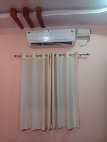 um quarto com um aquecedor e uma cortina de janela em Tharun home stay hampi em Hampi