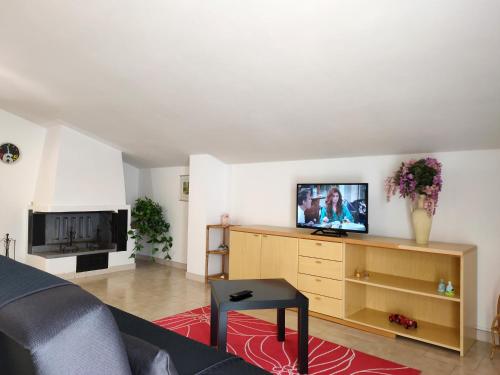 uma sala de estar com um sofá e uma televisão num armário em Attico mansardato luminoso em Orsogna