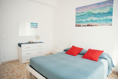 a bedroom with a bed with two red pillows at Case Vacanze Ganimede in Sperlonga