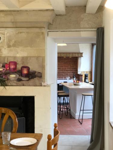eine Küche und ein Wohnzimmer mit einem Kamin in der Unterkunft Lolivia Gîte 8 personnes in Saint-Georges-sur-Cher