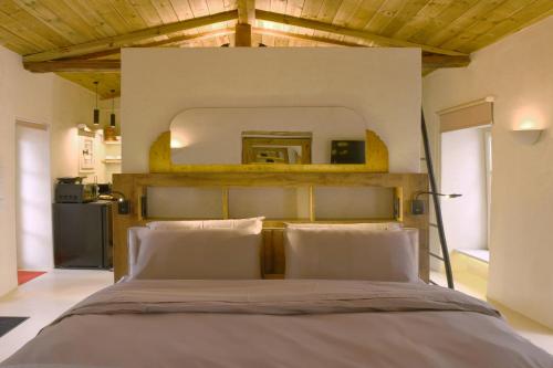um quarto com uma cama grande e uma cabeceira em madeira em SUITE HOUSE THISSION em Atenas