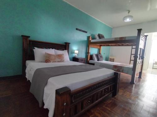 a bedroom with two bunk beds and green walls at Lajuela BnB & Hostel in Alajuela City