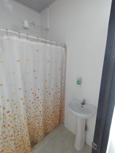a bathroom with a shower curtain and a sink at Lajuela BnB & Hostel in Alajuela City