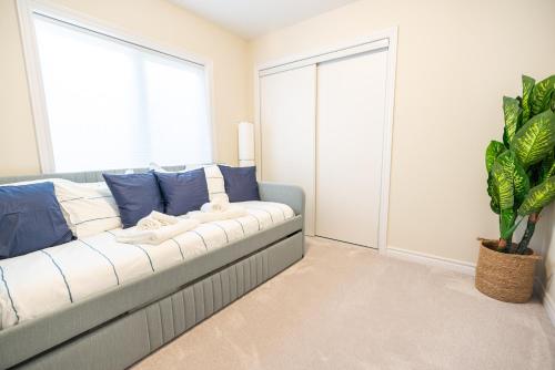 a living room with a couch and a plant at BRAND NEW home minutes from Niagara Falls. in Thorold