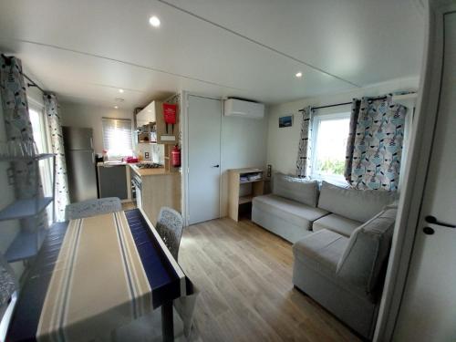 un petit salon avec un canapé et une table dans l'établissement MOBIL HOME CAMPING LES VIVIERS 4 ETOILEs, à Lège-Cap-Ferret
