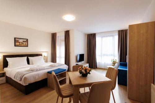 a hotel room with a bed and a table at Green Wood Hotel & Spa Bansko in Bansko