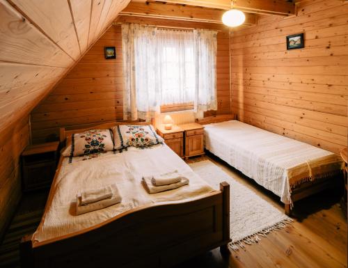 sypialnia z 2 łóżkami w drewnianym domku w obiekcie Willa Stasia w mieście Ustrzyki Dolne