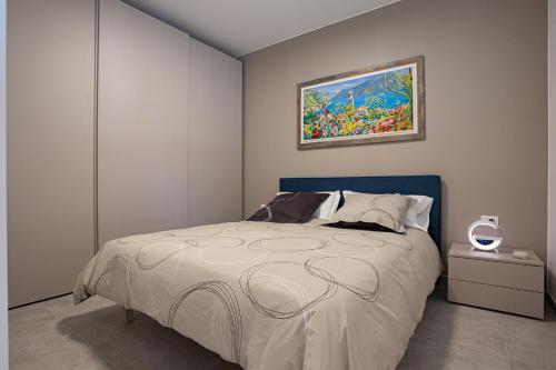 um quarto com uma cama com um quadro na parede em Casa Corand - Bardolino em Bardolino