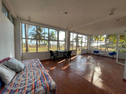 エル・クコにあるSugarloaf Beach House & Surf Lodgeのベッドとテーブルと椅子のある寝室