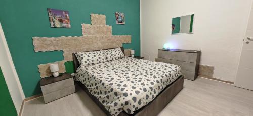 - une chambre avec un lit et un mur vert dans l'établissement La casa di Luca B&B, à Lacchiarella