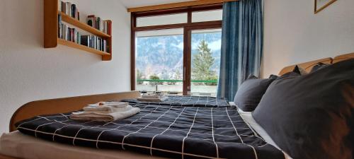een slaapkamer met een bed en een groot raam bij Direkter Seezugang am Ossiacher See, Radfahren und Wandern in Villach