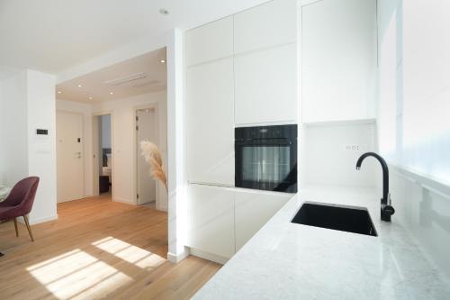 a kitchen with white cabinets and a stove top oven at Adria Concept Suites in Zadar