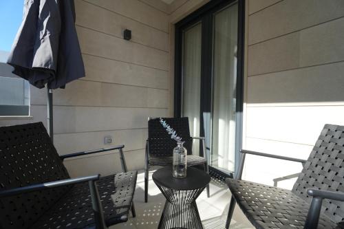 a patio with chairs and a table with a bottle on it at Adria Concept Suites in Zadar