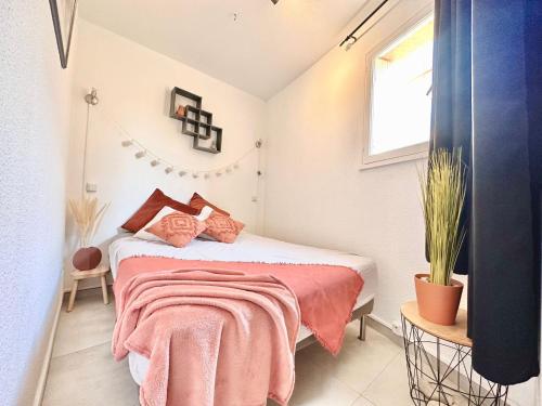 - une chambre avec un lit recouvert d'une couverture rose dans l'établissement La terrasse bandolaise tout à pied, wifi, clim, parking, à Bandol