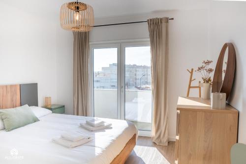 a bedroom with a bed and a large window at Casa do Parque - Santa Cruz in Santa Cruz
