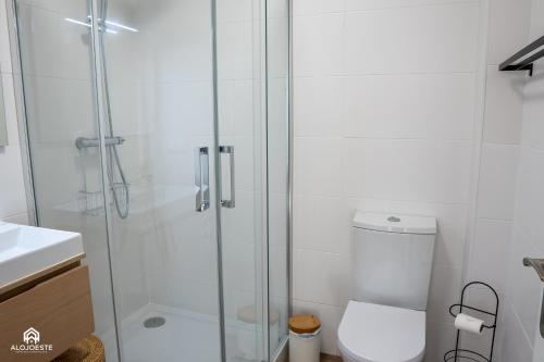 a bathroom with a toilet and a glass shower at Casa do Parque - Santa Cruz in Santa Cruz
