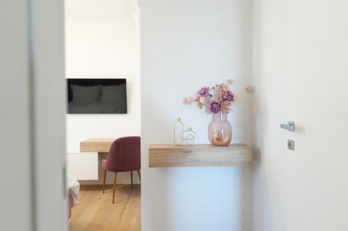 a vase of flowers on a table in a room at Adria Concept Suites in Zadar