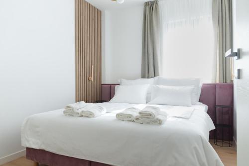 a bedroom with a white bed with towels on it at Adria Concept Suites in Zadar