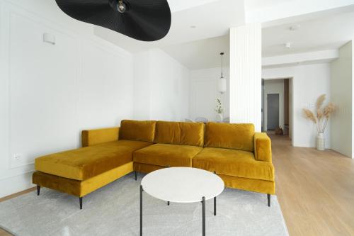 a living room with a yellow couch and a white table at Adria Concept Suites in Zadar
