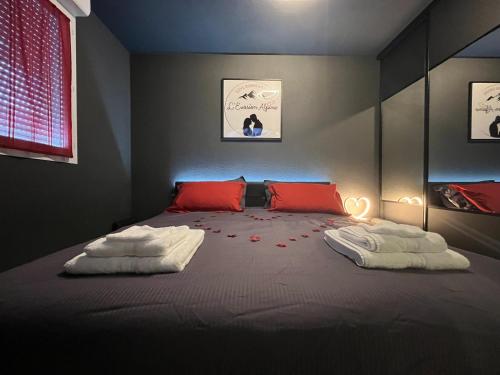 a bedroom with a large bed with red pillows at L'Evasion Alpine in Albertville