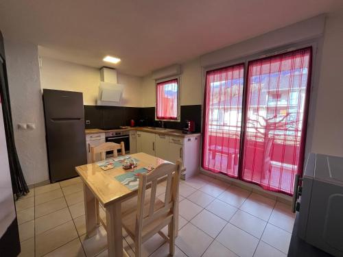 une cuisine avec une table et des chaises dans une pièce dans l'établissement L'Evasion Alpine, à Albertville