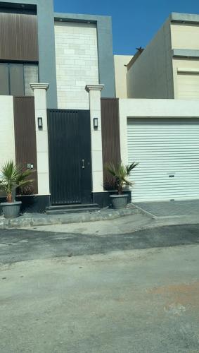 a building with two garage doors and palm trees at Ysso3 in Taif