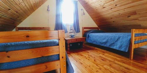 a attic bedroom with two beds and a window at Little Eden Summer Beach Home in Long Creek