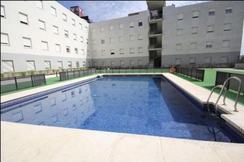 a large swimming pool in front of a building at ApartSur® in Bormujos