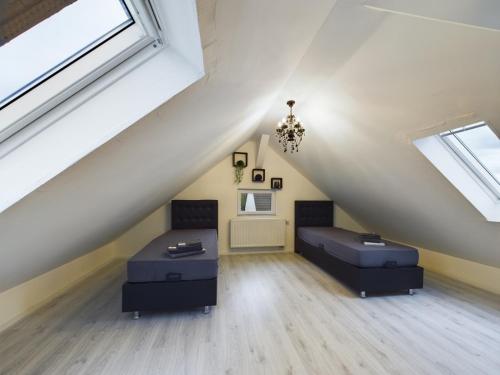 a attic bedroom with two beds and windows at Villa am Staderhof in Leichlingen