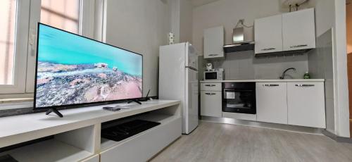 une cuisine avec une grande télévision à écran plat sur un comptoir dans l'établissement La casa di Luca B&B, à Lacchiarella