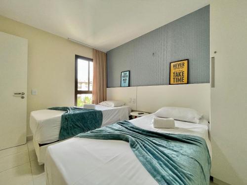 a hotel room with two beds and a window at Resort VG SUN por Be My Guest! in Caucaia