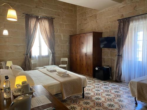 Habitación de hotel con 2 camas y mesa en Xemx, en Qala