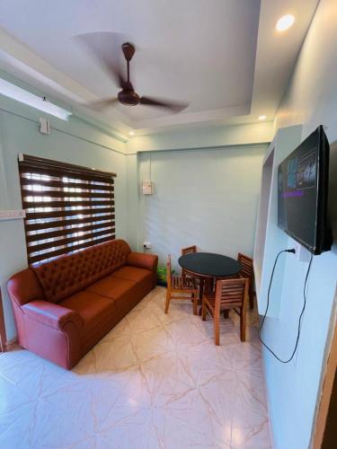 a living room with a couch and a table at FADHIYA RESIDENCY in Alwaye