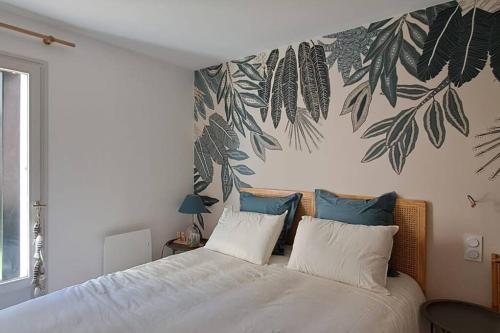 ein Schlafzimmer mit einem Bett mit einer Blätterwand in der Unterkunft Centre du Val André - appart en rez de jardin avec terrasse et jardinet - plage à 150 m in Pléneuf-Val-André