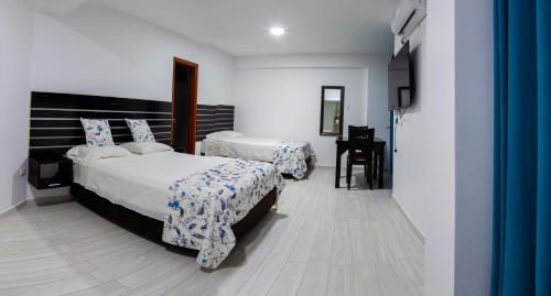 Habitación de hotel con 2 camas y escritorio en HOTEL BAMBOO, en Satipo