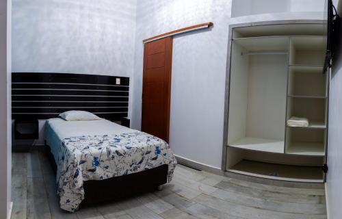 een kleine slaapkamer met een bed en een kast bij HOTEL BAMBOO in Satipo