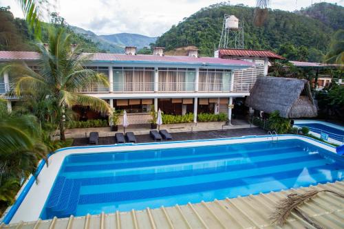 een villa met een zwembad voor een huis bij HOTEL BAMBOO in Satipo